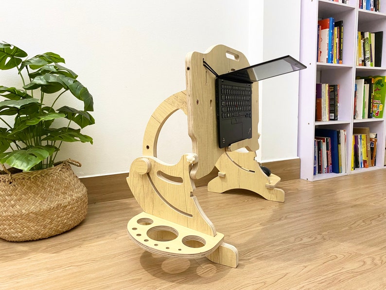 May include: A wooden laptop stand with a built-in mouse pad and cup holder. The stand is designed to elevate a laptop to a comfortable viewing height.