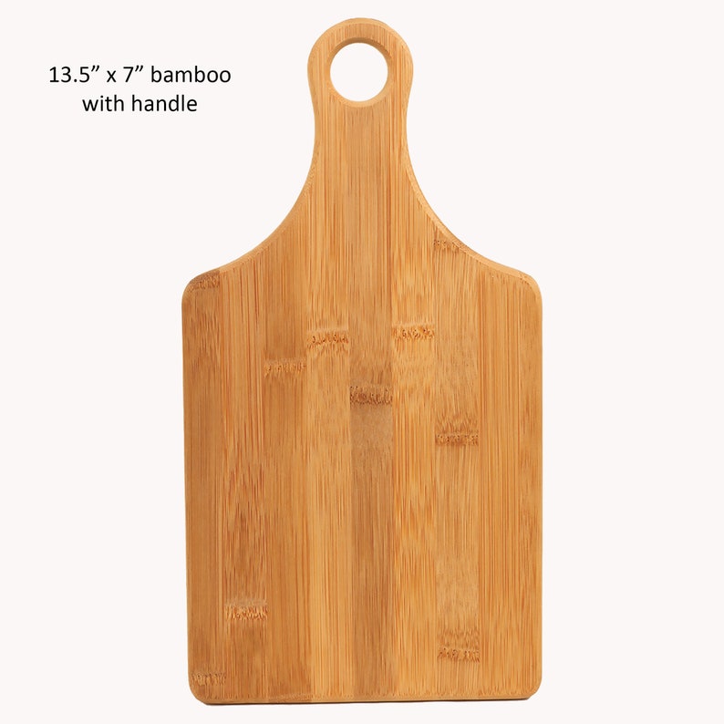 Op de afbeelding: Een 13,5 x 7 inch bamboe snijplank met een handvat. De plank is gemaakt van natuurlijk bamboe en heeft een lichtbruine kleur.