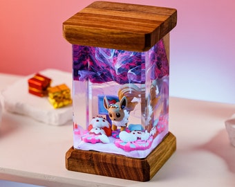 May include: A rectangular, wooden-framed resin art piece featuring a Pokemon character, Eevee, in a winter scene. The interior has a swirling, colorful design. The base and top are made of wood.
