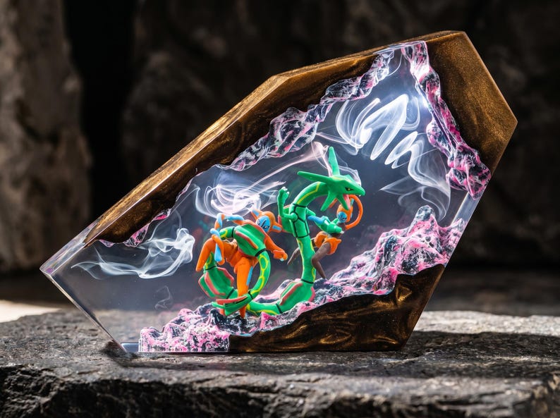 May include: A decorative resin and wood display piece featuring a green serpentine creature and an orange humanoid figure encased in clear resin. The structure includes dark wood edges, pink textured rock-like accents, and swirling white smoke effects.