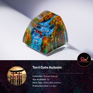 May include: Artisan keycap featuring a miniature Torii gate scene with a waterfall and autumn foliage. The keycap is encased in clear resin, showcasing the detailed landscape. The text "Torri Gate Autumn" is displayed.
