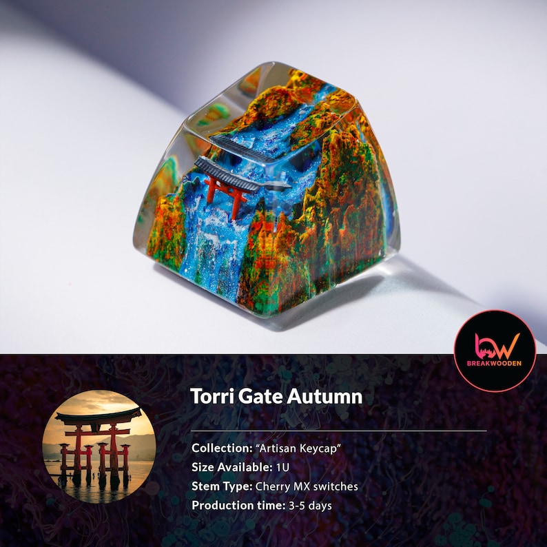 May include: Artisan keycap featuring a miniature Torii gate scene with a waterfall and autumn foliage. The keycap is encased in clear resin, showcasing the detailed landscape. The text "Torri Gate Autumn" is displayed.