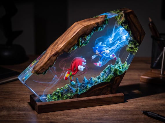 A hand-poured resin and epoxy wood lamp that traps Sonic & Knuckles in a glowing diorama — part night light, part shrine to 90s gaming.