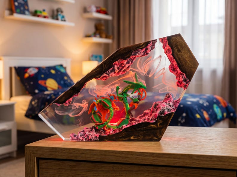 May include: A decorative resin lamp featuring a green serpentine dragon figure encased within a clear, angular block. The piece incorporates dark wood accents and textured, pink-hued rocky elements, with internal lighting creating a glowing effect.