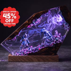 Può includere: Una lampada rettangolare in resina con una figura di Predator e un Alien racchiusi in un ambiente trasparente illuminato di viola con effetti di fumo vorticoso, su una base in legno. Un badge rosso mostra il testo SPECIAL OFFER! 45% OFF LIMITED TIME.