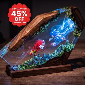 May include: A decorative resin and wood lamp featuring miniature figures of Sonic the Hedgehog and Knuckles the Echidna. The scene includes blue and red smoke-like effects within the clear resin, set on a rectangular wooden base.