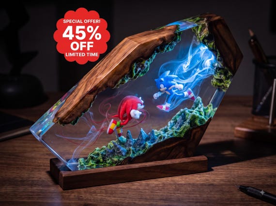 A hand-poured resin and epoxy wood lamp that traps Sonic & Knuckles in a glowing diorama — part night light, part shrine to 90s gaming.