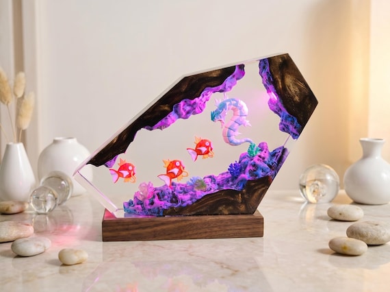 A hand-poured resin diorama lamp that encases a sea dragon and red fish in a glowing underwater cave — part night light, part fantasy terrarium art.