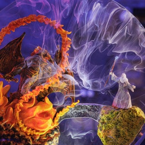 May include: A fantasy scene featuring a dragon engulfed in flames facing a wizard on a rocky outcrop. The dragon is brown and orange, with a fiery halo. The wizard is in a white robe, holding a staff. A stone bridge connects the two figures, with purple and white smoke.