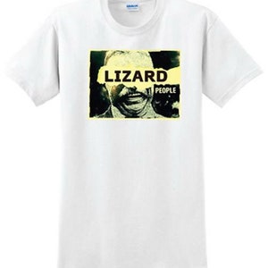 May include: White t-shirt with a graphic print of a man's face with the word "LIZARD" partially covering his face and the word "PEOPLE" below.
