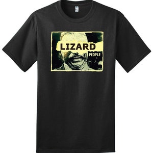 May include: Black t-shirt with a graphic of a man's face with the word "LIZARD" partially obscured by a yellow banner with the word "PEOPLE" printed on it.