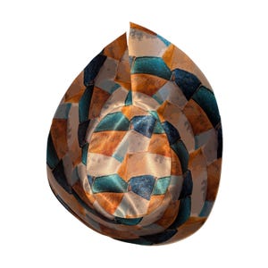 Op de afbeelding: Een patroonemmerhoed met een mozaïekontwerp in tinten oranje, blauwgroen, blauw en beige. Het oppervlak van de hoed is verdeeld in onregelmatige geometrische vormen, waardoor een textuur ontstaat. De hoed staat tegen een witte achtergrond.