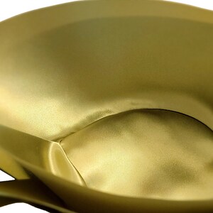 May include: A close-up of the inside of a gold satin fabric pouch. The fabric is smooth and has a soft, luxurious feel.