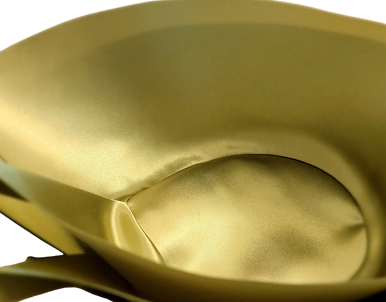 May include: A close-up of the inside of a gold satin fabric pouch. The fabric is smooth and has a soft, luxurious feel.