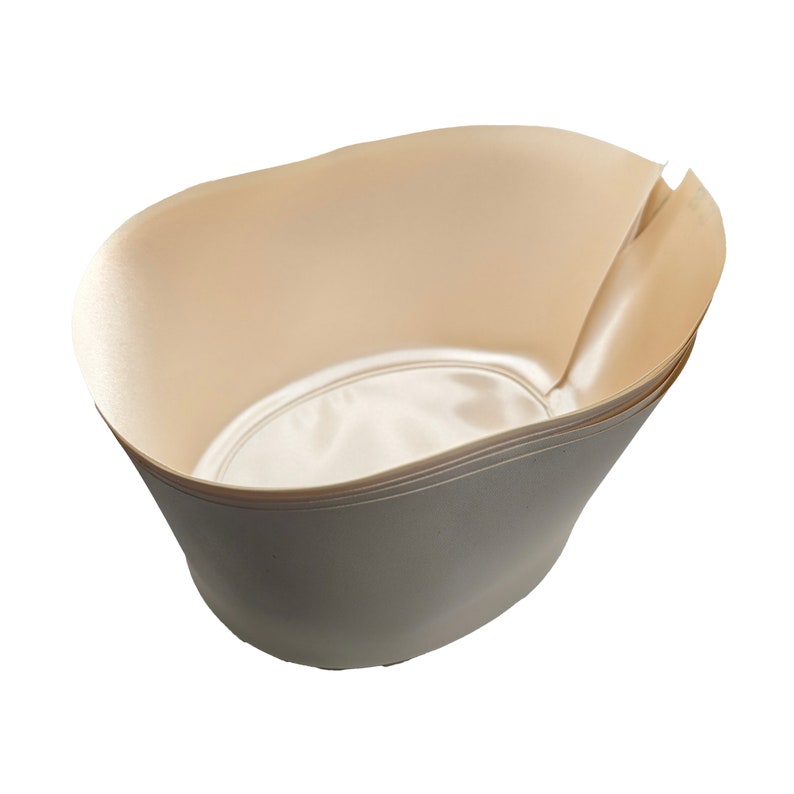 May include: A set of four beige paper bowls, stacked on top of each other. The bowls are oval shaped and have a smooth, slightly shiny finish.