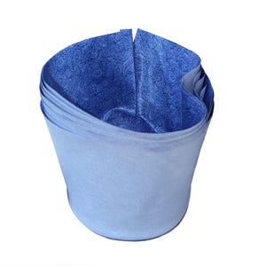 Peut inclure: Une pile de feuilles de papier de soie bleu clair, pliées en forme cylindrique. L'intérieur du cylindre est bleu plus foncé avec un motif cachemire. Le papier de soie est probablement destiné à l'emballage cadeau.