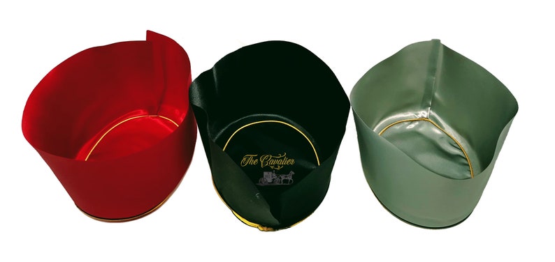 May include: Three open-top cylindrical containers in red, black, and sage green. The black container features the gold text The Cavalier with a carriage graphic on the interior base. Each container has a gold-colored circular trim at the base.