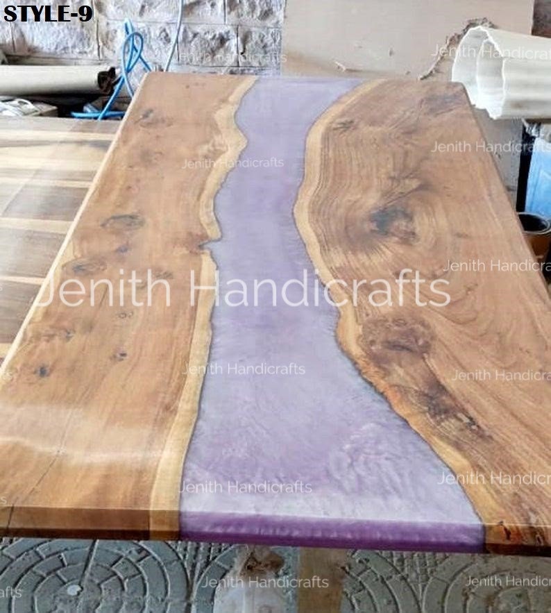 Op de afbeelding: Een houten tafelblad met een paarse harsrivier die door het midden loopt. Het hout is lichtbruin van kleur en de hars is lichtpaars van kleur. Het tafelblad is gemaakt door Jenith Handicrafts.