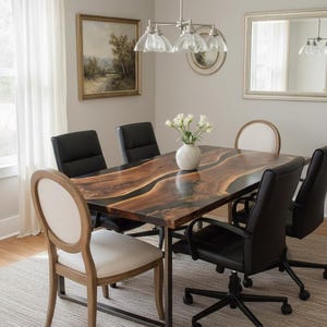 May include: A dining room set featuring a rectangular wooden table with a dark, flowing grain pattern and a black metal frame. The table is surrounded by a mix of black leather office chairs and wooden chairs with cream-colored upholstered seats. A vase of white flowers sits on the table.