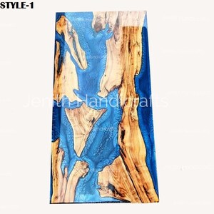 Op de afbeelding: Een rechthoekige houten tafelblad met een inleg van blauwe epoxyhars. De hars heeft een draaiende structuur en het hout heeft een natuurlijke nerf. Het tafelblad is ongeveer 61 cm breed en 91 cm lang.
