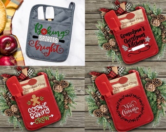 Op de afbeelding: Vier rode en grijze ovenwantjes met verschillende kerstthema's. De wantjes hebben een zakje voor een spatel en een zakje chocolade chips. De ontwerpen omvatten "Oma's Kerstkeuken", "Koekjes Bakken Crew", "Vrolijk Kerstfeest" en "Bakken Geest Helder".
