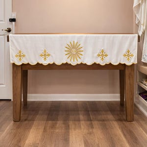 May include: A white ceramic mug with a black handle and the text "But First, Coffee" in a handwritten style. The mug is on a white surface. The mug is approximately 4 inches tall.