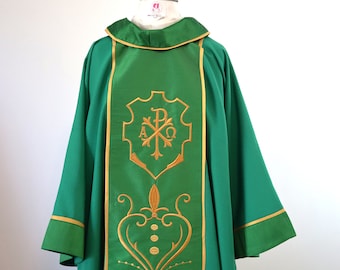 May include: Green liturgical vestment with gold embroidery. The embroidery features a stylized cross with the letters Alpha and Omega, and the letter P. The vestment has a gold trim around the edges.
