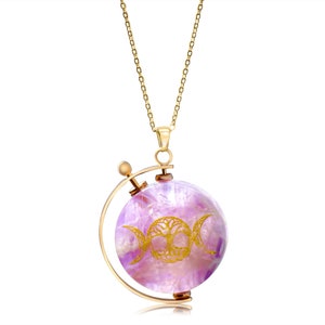 Op de afbeelding: Een gouden ketting met een draaiende amethist hanger met een gouden drievoudige maan en levensboom ontwerp.