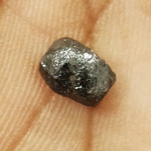 May include: A dark gray, irregularly shaped, rough-textured stone.
