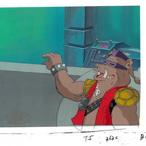 May include: A cartoon character with a pig snout, wearing a red vest with a skull and crossbones, a purple bandana, and a yellow turtle shell. The character is smiling and has a large, toothy grin.