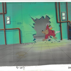 May include: An animation cel featuring a cartoon character, a brown anthropomorphic rat, in a red jacket, escaping through a hole in a green wall. The background includes pipes, a window, and a trash can.