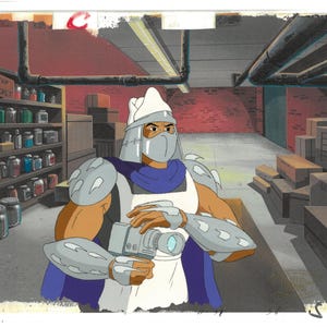 May include: An animated image of Shredder from Teenage Mutant Ninja Turtles holding a camera. He is wearing his signature silver armor, a white tunic, and a blue cape. The background shows a warehouse setting with shelves of jars.