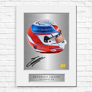 Op de afbeelding: Ingelijste racehelm met een rood, wit en blauw ontwerp, gesigneerd door Esteban Ocon. De naam "ESTEBAN OCON" en "ALPINE F1" staan eronder. Het nummer "31" is zichtbaar.