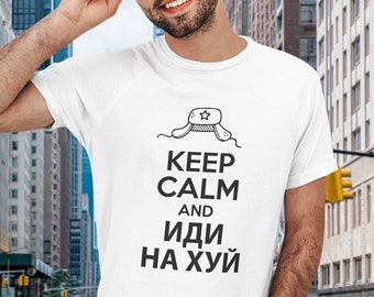 May include: White t-shirt with a black graphic print of a Russian Ushanka hat with a star on top. The text reads "Keep Calm and Иди на хуй".