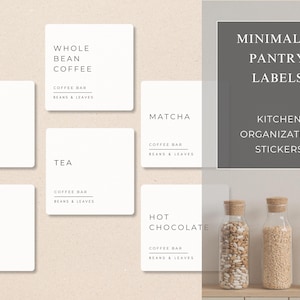 Op de afbeelding: Een verzameling minimalistische voorraadkastlabels en keukenorganisatiestickers. De labels bevatten tekst zoals "Whole Bean Coffee", "Decaf Coffee", "Tea", "Matcha", "Coffee" en "Hot Chocolate". Heldere glazen potten met kurken zijn ook zichtbaar.