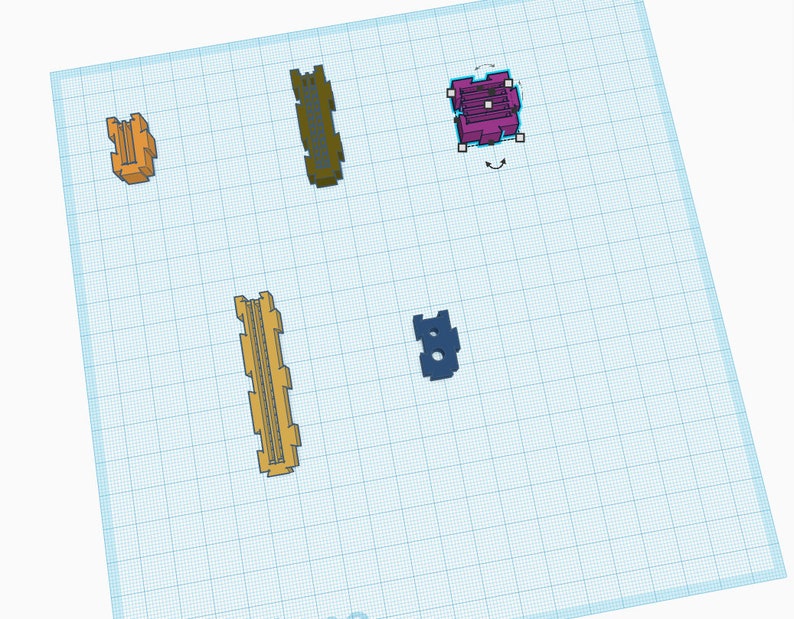 May include: Assortment of small plastic parts in various colors, including yellow, orange, purple, and blue. The parts are arranged on a grid background.