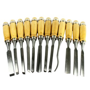 May include: A set of 12 wood carving chisels with wooden handles. The chisels have different blade shapes and sizes.