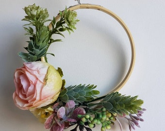 Small wreath with artificial flowers and cotton string hanging loop. The  hoop is 10cm in diameter with roses, berries, sprigs and foliage.