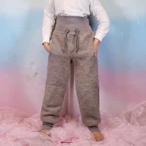 Könnte beinhalten: Ein Set aus drei Keramikbechern mit gesprenkelter, matter Oberfläche. Die Becher sind in Creme-, Hellgrau- und Dunkelgrautönen gehalten. Jeder Becher hat ein schlichtes, minimalistisches Design.