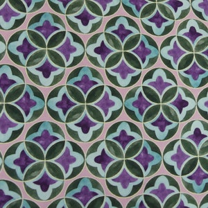 Op de afbeelding: Een herhalend patroon van teal, paarse en groene geometrische vormen op een licht roze achtergrond. Het patroon bestaat uit overlappende cirkels en vierbladige klavervormen.