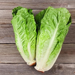May include: Two whole green romaine lettuce heads on a wooden surface.