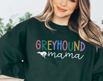 May include: A dark green sweatshirt with the text "Greyhound mama" in rainbow colors and a white silhouette of a running greyhound.