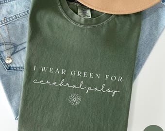May include: A green t-shirt with the text "I wear green for cerebral palsy" and a small flower graphic. The shirt is a moss green colour.