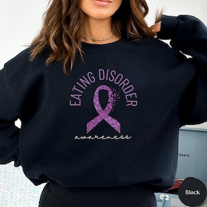 May include: Black sweatshirt with the text "Eating Disorder Awareness" and a purple ribbon with a dotted pattern.