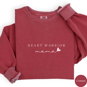 May include: Crimson red sweatshirt with the text "HEART WARRIOR mama" and a small pink heart.