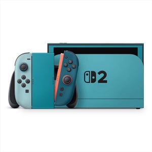 May include: A teal and black video game console with two detachable controllers. The controllers are light blue and teal with black buttons and a coral-colored side. The console has the number "2" printed on it.