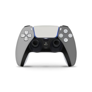 Puede incluir: Un mando inalámbrico PlayStation 5 DualSense blanco y gris con botones negros y el logotipo de PlayStation.