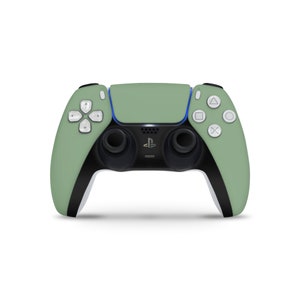 May include: A green PlayStation 5 DualSense wireless controller with white buttons and black accents. The controller has a PlayStation logo on the front.