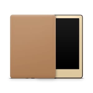 May include: A closed tan e-reader with a gold trim and a black screen.