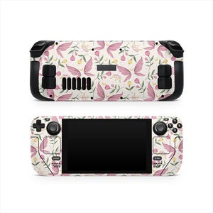 May include: A handheld gaming console with a floral design. The console features a cream-colored background with pink fairy wings, flowers, and green leaves. The console has black control buttons and a black screen.